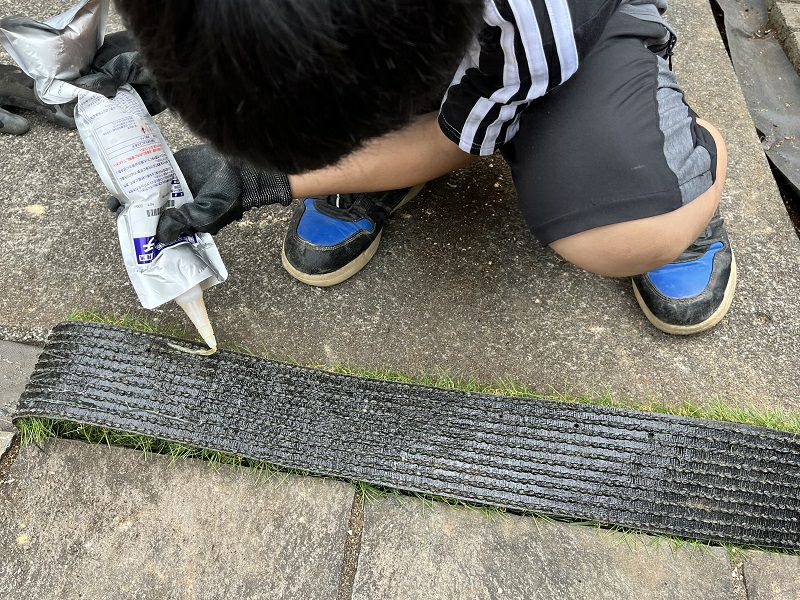 人工芝と防草シートを接着剤ウレタッチで固定します